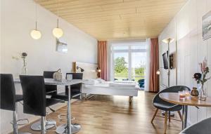 アリンエにあるStunning Apartment In Allinge With Wifiのテーブルと椅子とベッドのあるリビングルーム