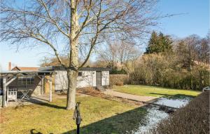 a house with a tree in the yard at Lovely Home In Gudhjem With Wifi in Gudhjem