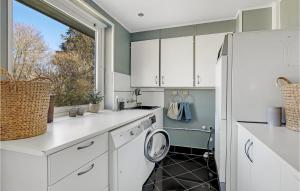 a kitchen with white cabinets and a window at Lovely Home In Gudhjem With Wifi in Gudhjem