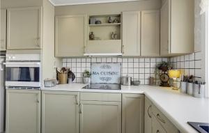 a kitchen with white cabinets and white appliances at Lovely Home In Gudhjem With Wifi in Gudhjem