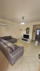 a living room with a couch and a tv at Vila Roan in Vlorë