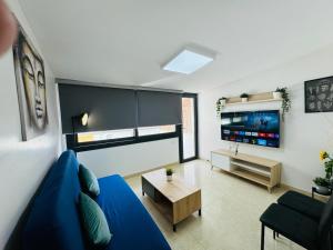 a living room with a blue couch and a tv at 4'min to beach and tren 15 min to plaza catalunya by tren in Sant Adria de Besos