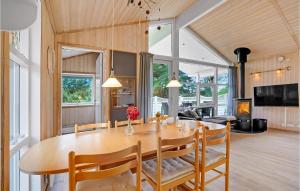 a dining room and living room with a table and chairs at Holiday Home Mågelunden Rødby I in Kramnitse
