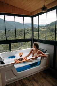 a woman in a bath tub in a room with windows at Vaio Resort in Keda in Keda