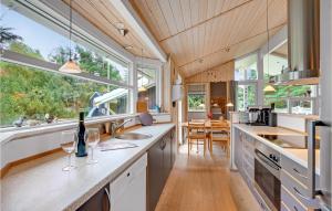 a kitchen with windows and a counter with wine glasses at Holiday Home Mågelunden Rødby I in Kramnitse