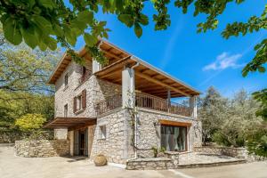 an exterior view of a stone house with a balcony at Apanema Mindfulness Resort Lefkada - ultra fast Starlink WiFi in 2025 in Asprogerakata