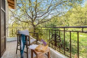 a balcony with a chair and a table and a tree at Apanema Mindfulness Resort Lefkada - ultra fast Starlink WiFi in 2025 in Asprogerakata