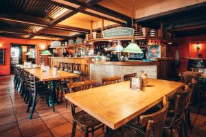 a restaurant with wooden tables and chairs and a bar at Braugasthof Trompete in Eichstätt