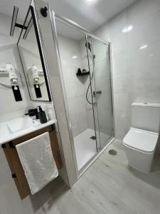 a bathroom with a shower and a toilet and a sink at Apartamento BURELA PALOMA PLAYA in Burela de Cabo +21 photos