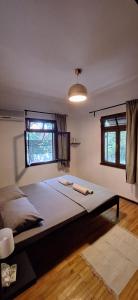 a large bed in a room with two windows at Summer house in Urla "Apartment 1" in Urla