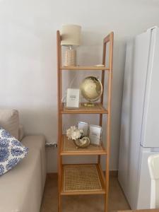 a wooden shelf with items on it next to a bed at San Miguel Apartment Amadores Beach in Puerto Rico de Gran Canaria