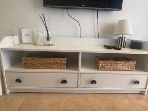 a white shelf with two baskets and a lamp on it at San Miguel Apartment Amadores Beach in Puerto Rico de Gran Canaria +23 photos