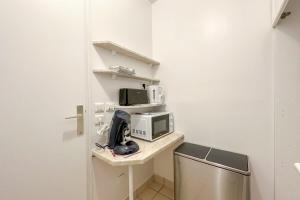a kitchen with a counter with a microwave and a sink at Flexliving - room - Hillairet in Paris +1 photo