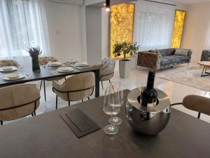 a living room with a table with a bottle of wine at Berenát Villa in Nyíregyháza