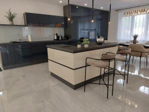 a kitchen with a counter and stools in it at Berenát Villa in Nyíregyháza +42 photos