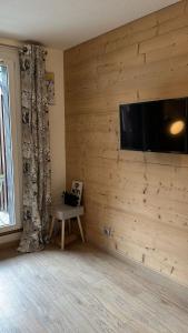 een kamer met een houten muur en een flatscreen-tv bij STUDIO DENT DU CROCODILE, AIGUILLE du MIDI, BALCON, PARKING in Chamonix-Mont-Blanc