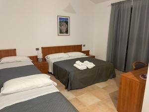 a hotel room with two beds with towels on them at La Locanda del Brigante in Farindola