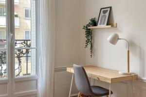 a desk with a chair next to a window at Flexliving - room - Hameau in Paris
