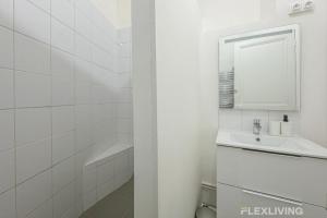 une salle de bain blanche avec un lavabo et un miroir dans l'établissement Flexliving - Room - Henri Sellier - Suresnes 92, à Suresnes 1 autre photo