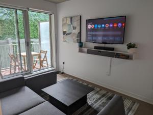 un salon avec un canapé et une télévision sur un mur dans l'établissement Cozy Studio in Montreal's Quartier des Spectacles, à Montréal