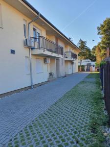 a house with a brick driveway next to a building at MANDARA WELLNES APARTMANOK in Siófok