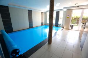 a swimming pool with blue lighting in a building at MANDARA WELLNES APARTMANOK in Siófok