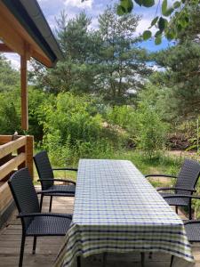 a table and chairs on a deck with a tablecloth on it at Tiny House am See in Casel +5 photos