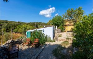 a patio with a table and chairs in front of a building at 2 Bedroom Lovely Home In Punta Kriza in Nerezine