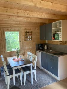 a kitchen and dining room with a table in a cabin at Tiny House am See in Casel