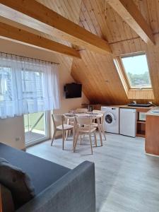a kitchen and dining room with a table and chairs at Helios in Dębki