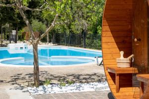 a swimming pool with a bench next to a tree at Apanema Mindfulness Resort Lefkada - ultra fast Starlink WiFi in 2025 in Asprogerakata