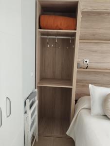 a small bedroom with a bed and a wooden wall at Apartamento La Fuente 27 in Tomares +44 photos