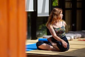 a woman sitting on the floor with a laptop at Apanema Mindfulness Resort Lefkada - ultra fast Starlink WiFi in 2025 in Asprogerakata