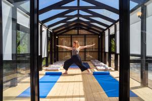 a woman doing a yoga pose in the middle of a building at Apanema Mindfulness Resort Lefkada - ultra fast Starlink WiFi in 2025 in Asprogerakata