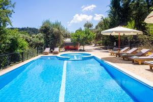a swimming pool with chairs and an umbrella at Apanema Mindfulness Resort Lefkada - ultra fast Starlink WiFi in 2025 in Asprogerakata