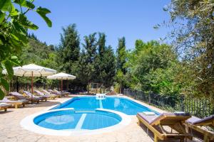 a swimming pool with lounge chairs and an umbrella at Apanema Mindfulness Resort Lefkada - ultra fast Starlink WiFi in 2025 in Asprogerakata