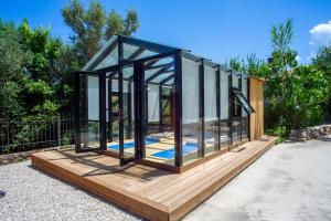 a glass house sitting on a wooden deck at Apanema Mindfulness Resort Lefkada - ultra fast Starlink WiFi in 2025 in Asprogerakata