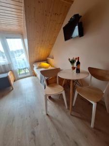 a small room with a table and chairs and a bed at Helios in Dębki