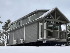 a small house with two chairs in front of it at Cozy Cabins with a mountain view 2A in Williams