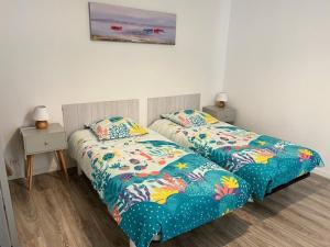 a bedroom with two beds and two night stands at ARCACHON CENTRE 6 mn de la plage à pied 4 chambres 8 couch in Arcachon