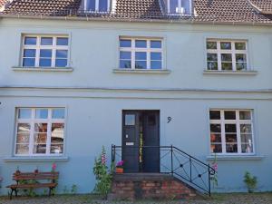 een blauw huis met een blauwe deur en trap bij Wohnung in Wismar mit Garten in Wismar