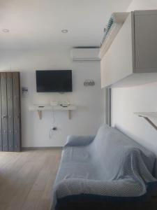a bedroom with a bed and a tv on the wall at La casita de Valeria in El Palmar
