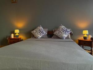 a bedroom with a large bed with two lamps at Huizenmarkt Caboverde in Mindelo