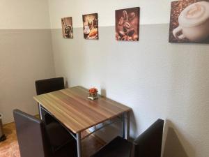 una mesa y sillas en una habitación con cuadros en la pared en Gästewohnung am Stadtpark, en Meerane 4 fotos más