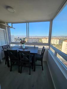 a table and chairs in a room with a large window at Departamento Edificio Playa Blanca in La Serena +5 photos