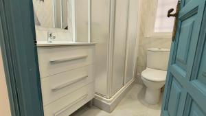 Un baño blanco con lavabo e inodoro. en Casa Roda 39, en A Guarda