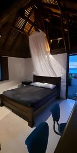 a bedroom with a bed and blue chairs at Club Cean in Madroñal