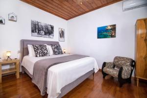 a bedroom with a bed and a chair at Mikros Paradisos Pelion in Áyios Vlásios