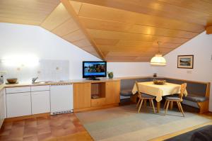 a kitchen and dining room with a table and a television at Residence Granvara in Ortisei