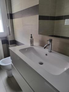 a bathroom with a white sink and a toilet at Partenope in Termoli +29 photos